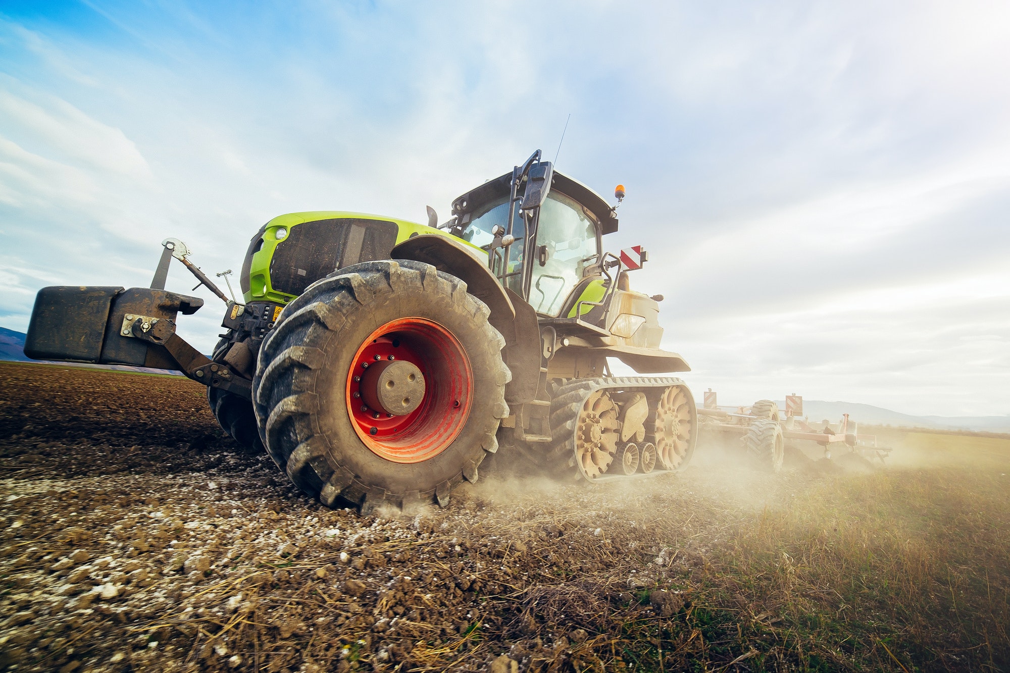Modern tractor working on the field. Tractor plowing fields preparing land for sowing